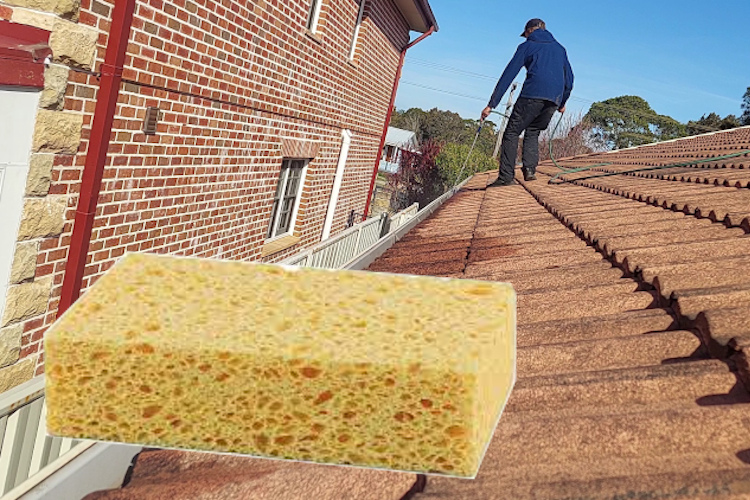 gutter cleaning service in nowra is cleaning out a gutter with a sponge due to poor access to water during droughts.